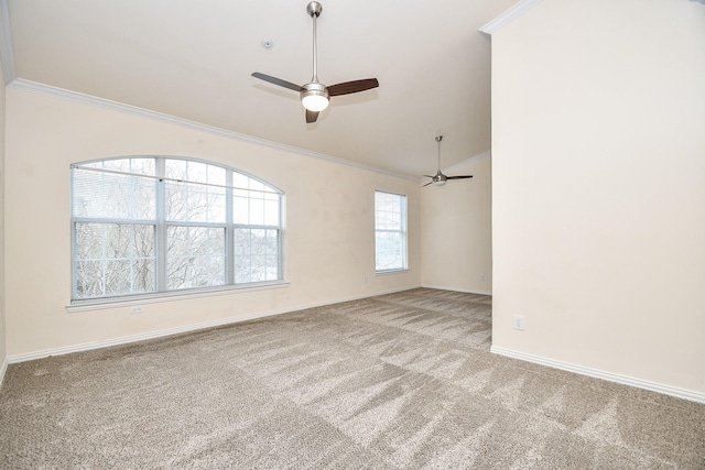 carpeted spare room featuring a ceiling fan, vaulted ceiling, crown molding, and baseboards