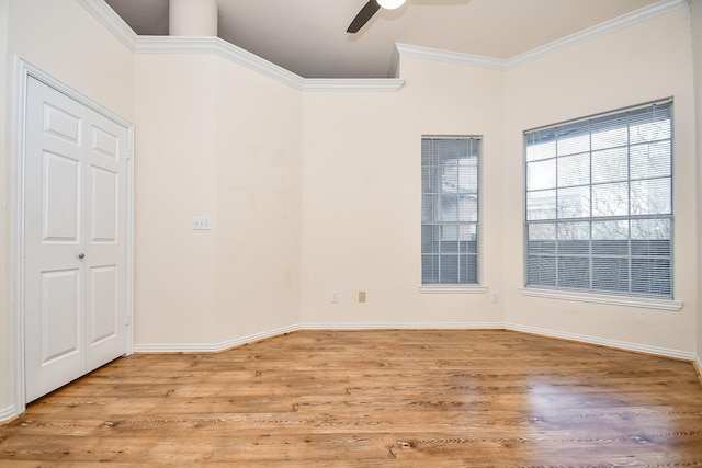 empty room featuring light wood finished floors, baseboards, ornamental molding, and a ceiling fan