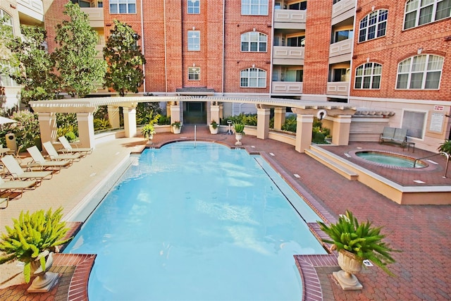 view of swimming pool featuring a pergola and a community hot tub