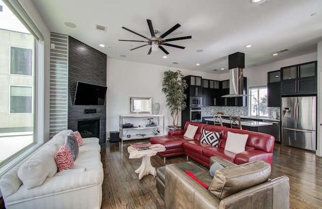 living area featuring a fireplace, visible vents, dark wood-type flooring, and recessed lighting