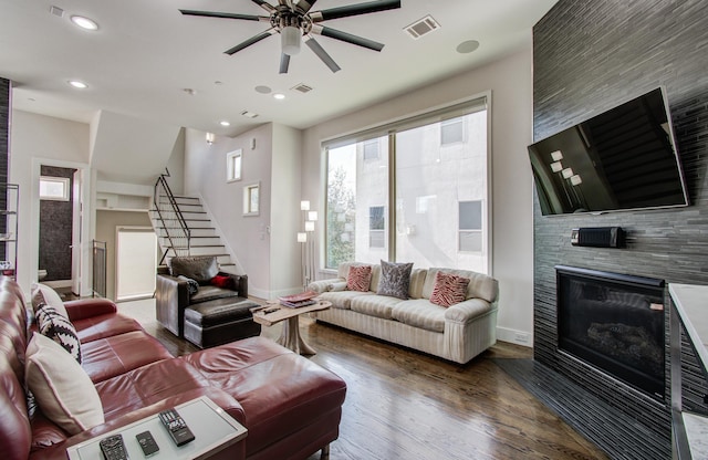 living room with recessed lighting, a fireplace, wood finished floors, visible vents, and stairway