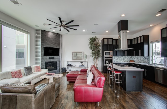 living room with dark wood finished floors, visible vents, a fireplace, and recessed lighting