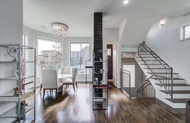 dining space with plenty of natural light, stairway, and dark wood finished floors