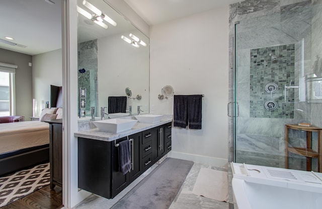 ensuite bathroom featuring a sink, a stall shower, connected bathroom, and a tub