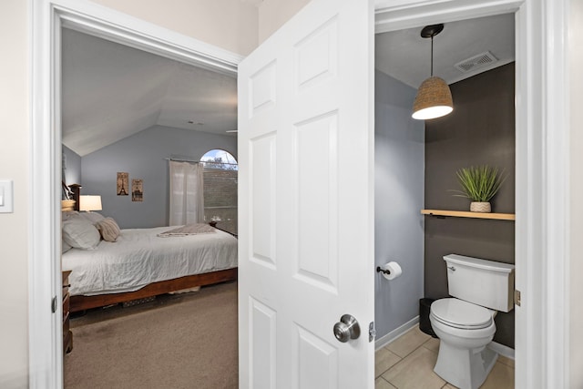 interior space featuring tile patterned floors, toilet, and vaulted ceiling