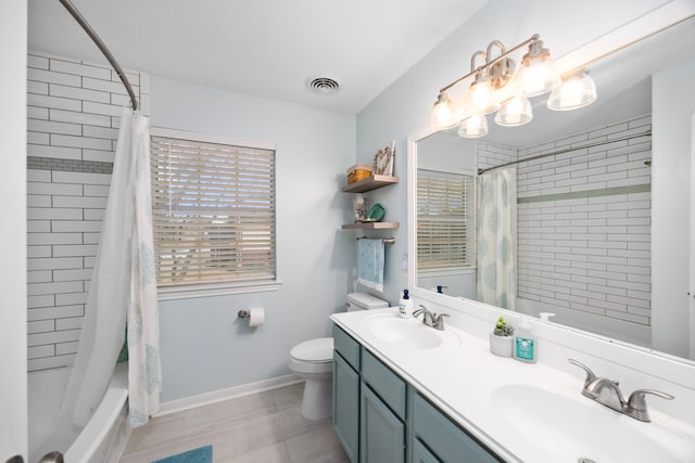 full bathroom with shower / tub combo with curtain, vanity, and toilet