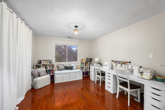 home office with dark hardwood / wood-style flooring and a textured ceiling