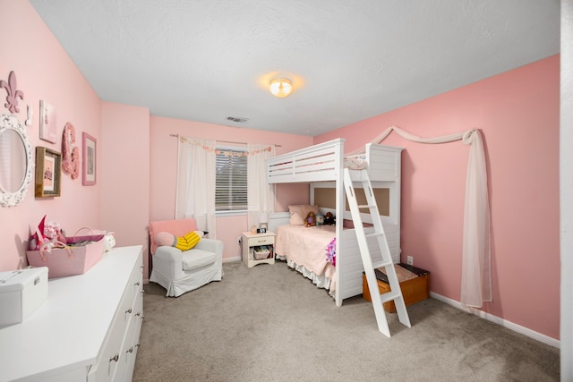 bedroom with carpet floors and a textured ceiling