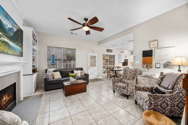 living room with ceiling fan, light tile patterned floors, and a fireplace