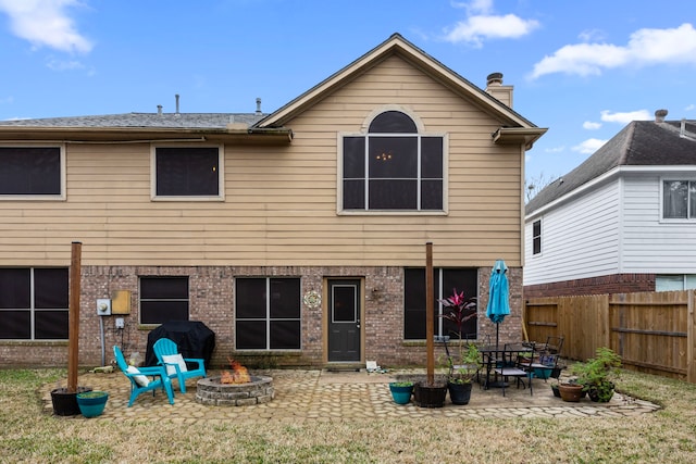 back of property featuring a fire pit and a patio