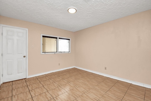 tiled empty room with a textured ceiling