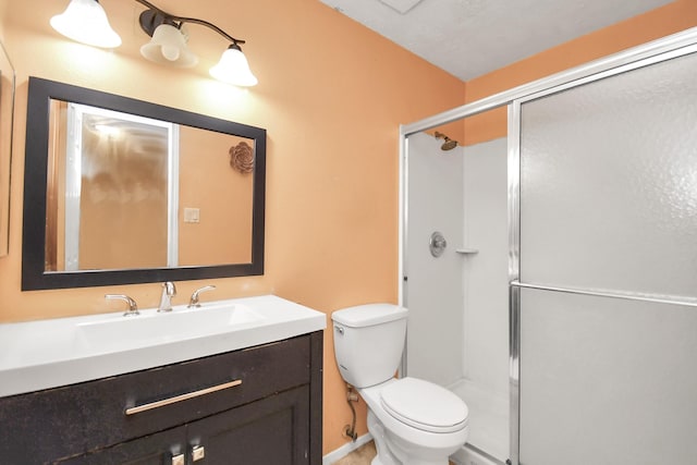 bathroom featuring vanity, toilet, and a shower with door