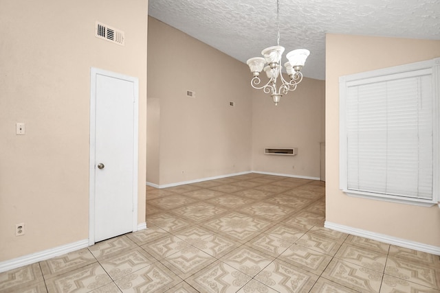 unfurnished room with a textured ceiling, vaulted ceiling, and a chandelier