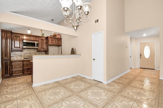 kitchen with an inviting chandelier, backsplash, high vaulted ceiling, a textured ceiling, and light tile patterned flooring