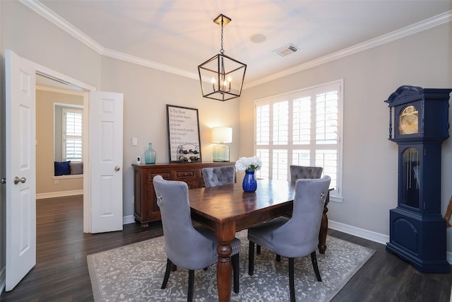 dining area with dark wood-type flooring, ornamental molding, a chandelier, and a healthy amount of sunlight