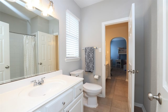 bathroom with tile patterned flooring, vanity, toilet, and walk in shower