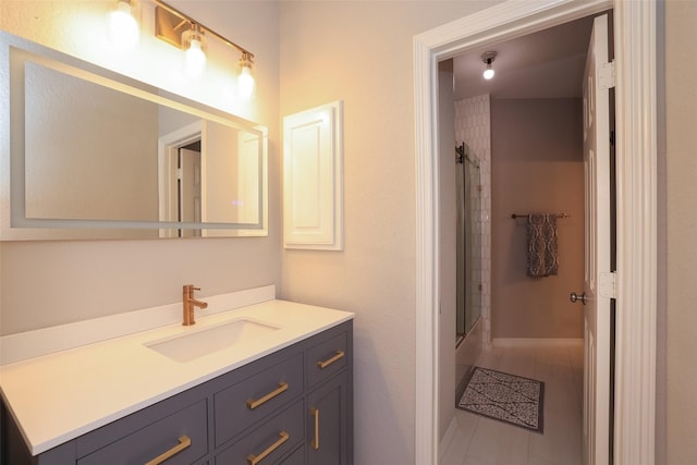 bathroom with vanity and bath / shower combo with glass door