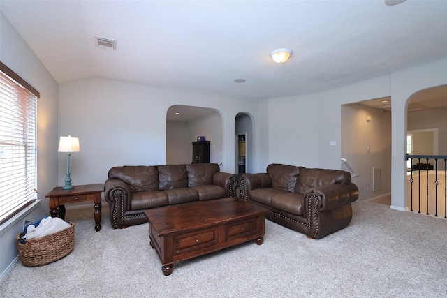 living room featuring lofted ceiling and light carpet