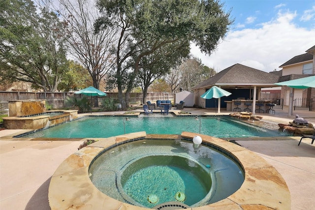 view of pool featuring an in ground hot tub, a bar, and a patio area