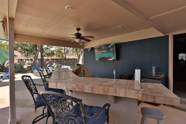 view of patio / terrace featuring exterior bar, a grill, and ceiling fan