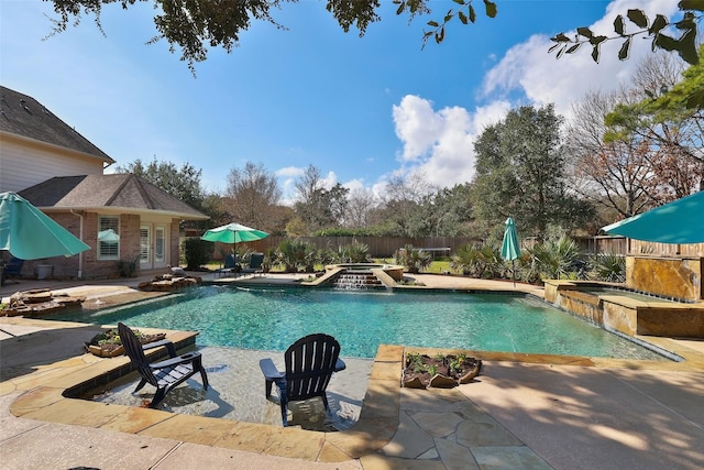 view of swimming pool featuring a patio area, pool water feature, and an in ground hot tub