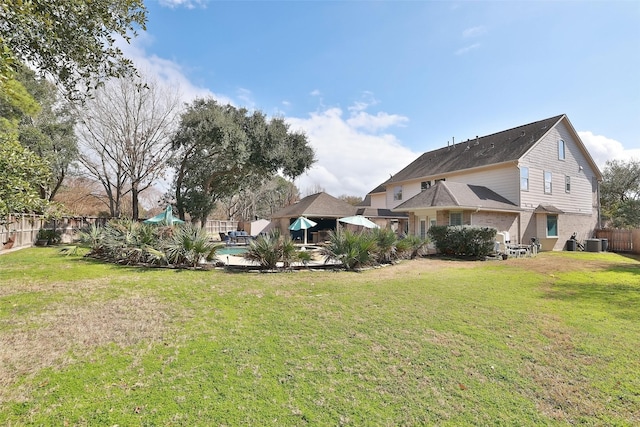 view of yard with a pool and central AC unit