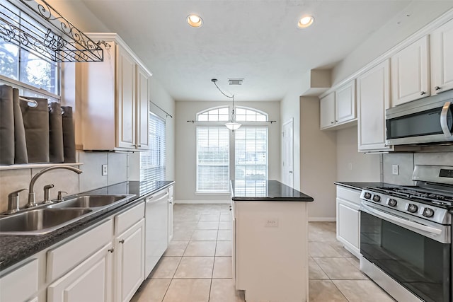 kitchen featuring pendant lighting, white cabinetry, sink, a center island, and stainless steel appliances