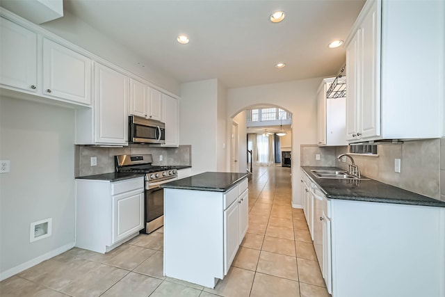 1408 S Friendswood Dr Unit 101, Friendswood, TX 77546 - kitchen with appliances with stainless steel finishes, a sink, arched walkways, dark countertops, and recessed lighting