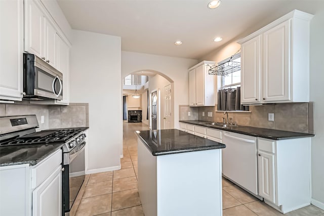 kitchen featuring light tile patterned flooring, sink, white cabinetry, a center island, and stainless steel appliances