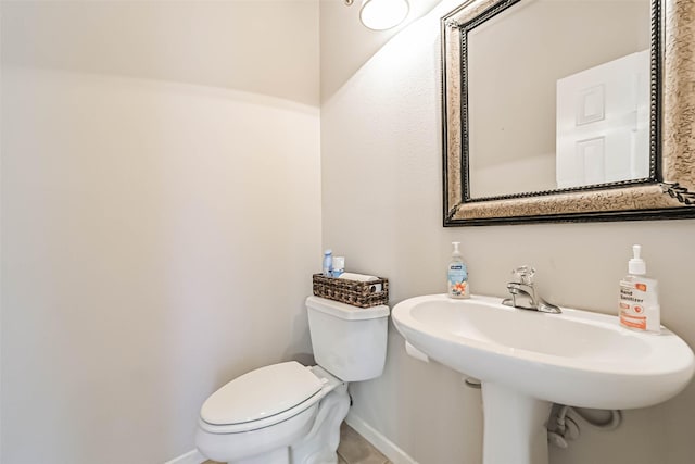 1408 S Friendswood Dr Unit 101, Friendswood, TX 77546 - half bathroom with baseboards, toilet, a sink, and tile patterned flooring