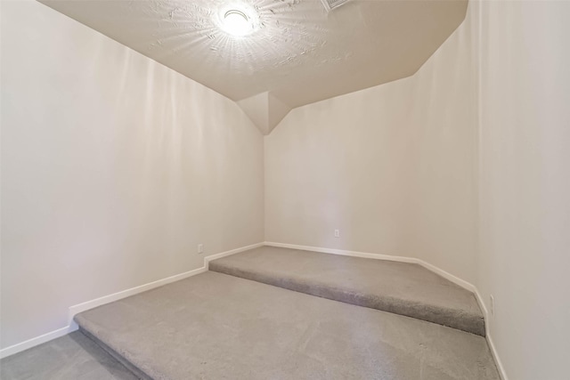 unfurnished room with vaulted ceiling and carpet floors