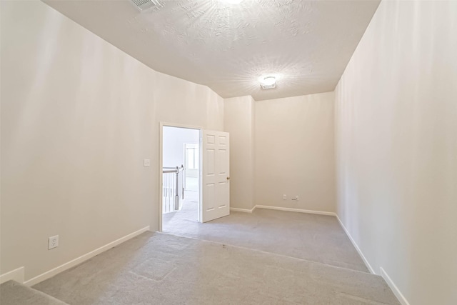 carpeted spare room featuring a textured ceiling