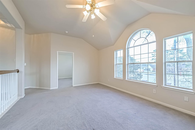 empty room with lofted ceiling, light carpet, and ceiling fan