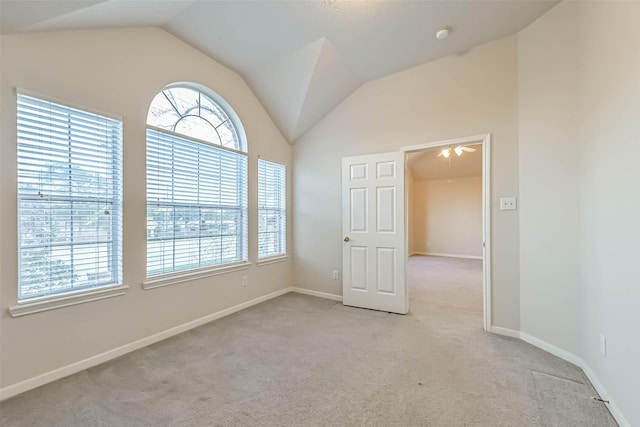 empty room featuring light colored carpet and lofted ceiling