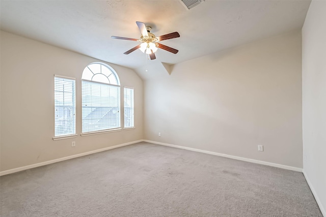 empty room with vaulted ceiling, carpet flooring, and ceiling fan