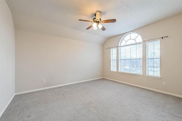 empty room with ceiling fan, carpet floors, and vaulted ceiling