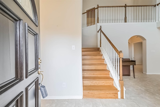 1408 S Friendswood Dr Unit 101, Friendswood, TX 77546 - foyer featuring a high ceiling, stairway, arched walkways, and light tile patterned floors