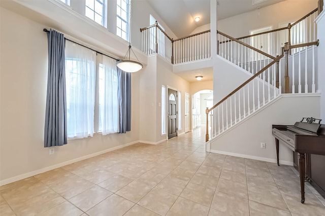 tiled entryway with a towering ceiling