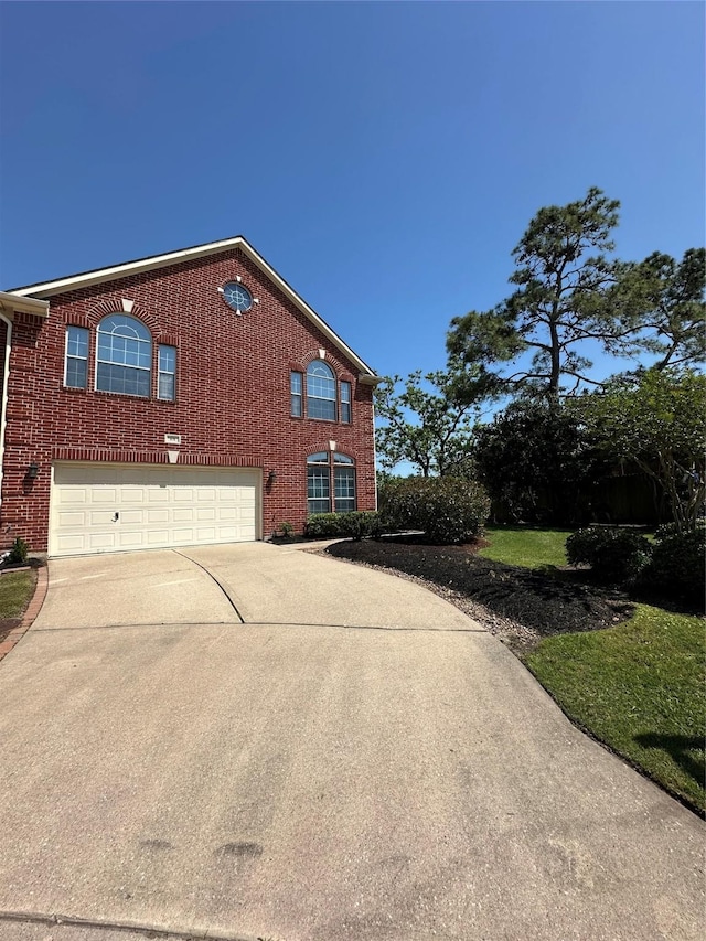 view of front of home featuring brick siding, an attached garage, and concrete driveway