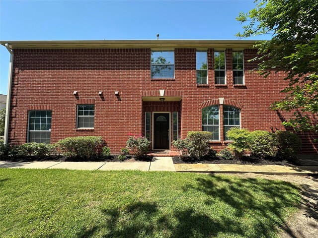 colonial house with brick siding and a front lawn