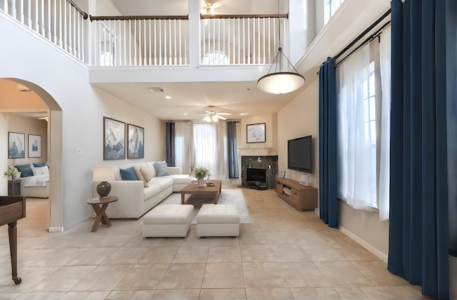 1408 S Friendswood Dr Unit 101, Friendswood, TX 77546 - living area with ceiling fan, a towering ceiling, arched walkways, light tile patterned floors, and baseboards