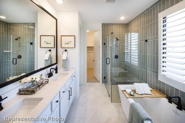 bathroom featuring a sink, a shower stall, and plenty of natural light