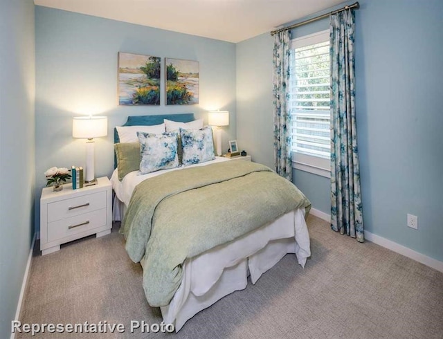 bedroom with light carpet and baseboards
