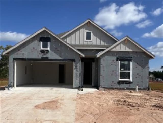 property under construction featuring board and batten siding, a garage, and driveway