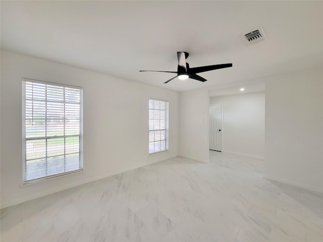 spare room featuring a healthy amount of sunlight and ceiling fan