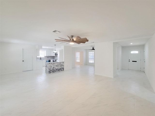 unfurnished living room featuring ceiling fan