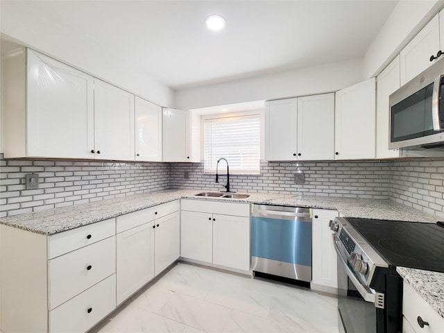 kitchen featuring sink, stainless steel appliances, white cabinets, and light stone countertops