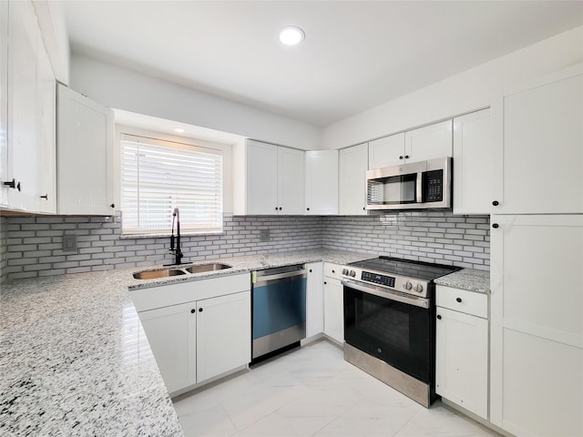 kitchen featuring sink, stainless steel appliances, white cabinets, and light stone countertops