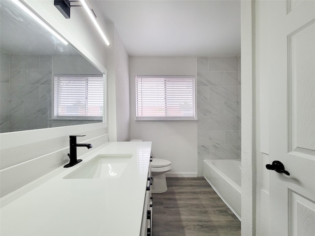 full bathroom with hardwood / wood-style flooring, vanity, plenty of natural light, and toilet