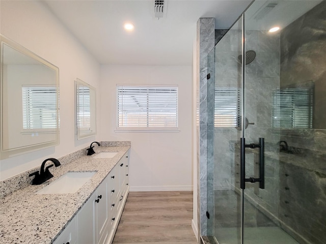 bathroom with a shower with door, vanity, and hardwood / wood-style floors